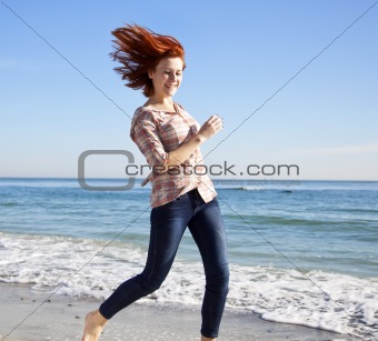 Beautiful young woman running on the beach 