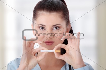 Young woman breaking cigarette