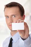 Businessman holding blank card