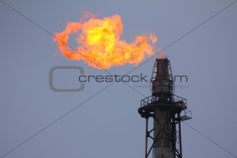 torch is lit on tower refinery