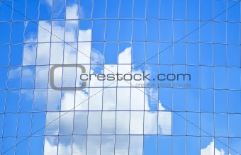 highrise glass building with sky and clouds reflection 