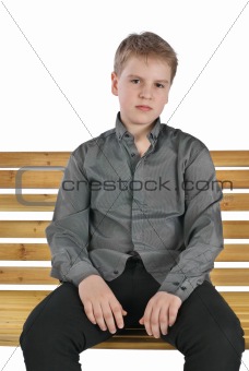 Serious boy sitting on a bench