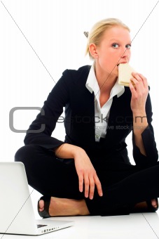 businesswoman eating sitting on the floor with laptop