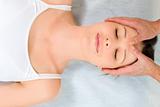 woman lying down receiving head massage
