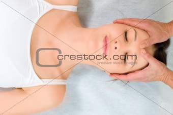 woman lying down receiving head massage