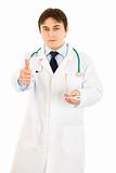 Doctor holding  medical thermometer in hand and showing thumbs up gesture
