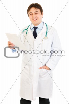 Smiling medical doctor holding document in hand
