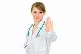 Strict medical female doctor showing stop gesture
