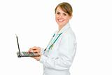 Smiling medical female doctor using laptop
