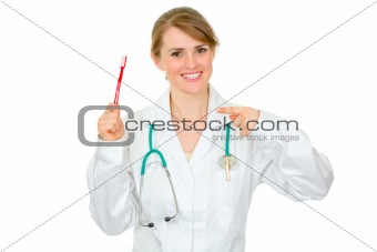 Smiling dentist female pointing finger on toothbrush. Concept - healty teeth
