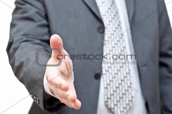Businessman in dark suit extending hand to shake