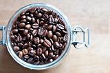 Rich dark coffee beans in a glass recipient