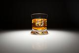 Glass of Whiskey or Other Alcoholic Drink and Ice Under Spot Light.