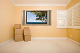 Flat Panel Television on Wall with Tropical Scene in Empty Room with Boxes.