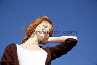 Portrait of red-haired girl on blue background.