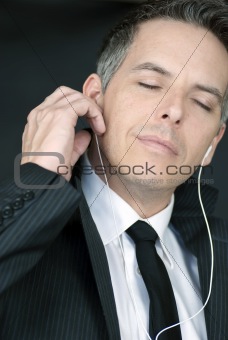 Serene Businessman Puts In Headphones