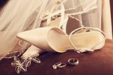 Wedding shoes with veil and rings on velvet chair