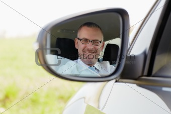 businessman in car smiling at camera
