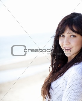 Pretty young woman with standing on beach 