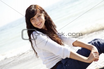 Pretty young woman with sitting on beach