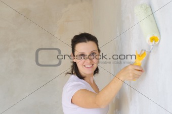 Young Woman Painting A Wall