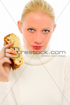 woman wearing a white turtleneck sweater and holding a slice of panettone