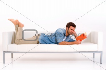 man on the couch reading a book