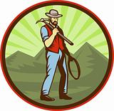 Miner carrying pick axe with mountains 