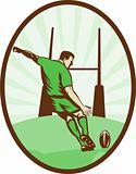 Rugby player kicking ball at goal post 
