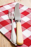 Antique knife and fork on a red and white cloth