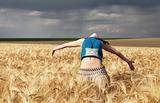 Girl at wheat field in storm day.