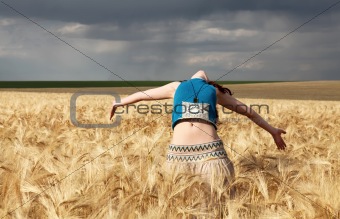 Girl at wheat field in storm day.