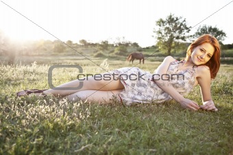 Girl at grass field at sunset. Photo in old image style.