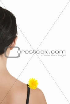 Yellow flower on shoulder at woman kind from back