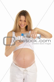 pregnant woman pours water into a glass