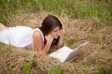 Young  fashion girl with notebook lying at field