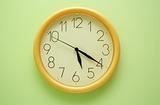 Yellow wall clock on the green