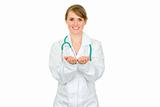 Smiling female medical doctor presenting something on empty hands
