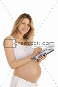 happy pregnant woman wrote in a notebook