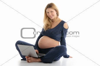 pregnant woman with a laptop sitting on the floor