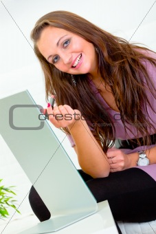 Smiling pretty woman sitting in front of mirror and applying lipstick 
