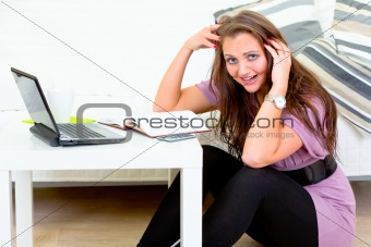 Stressed young housewife sitting on floor and calculate her expenses 
