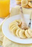 banana cut into slices on a plate with honey, healthy breakfast