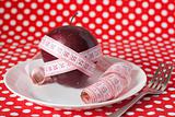 Red apple and measuring tape on a white plate