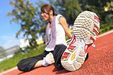 woman doing stretching exercise in sport field