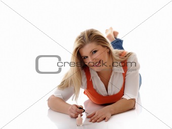 Beautiful girl relaxing and applying nail polish making manicure