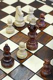 wooden chess figures on brown game board