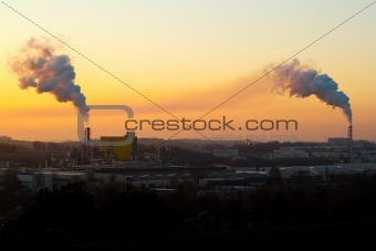 Sunrise silhouette of smoking factory