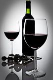 two wineglasses with red wine and bottle