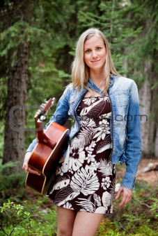 Female holding guitar against trees